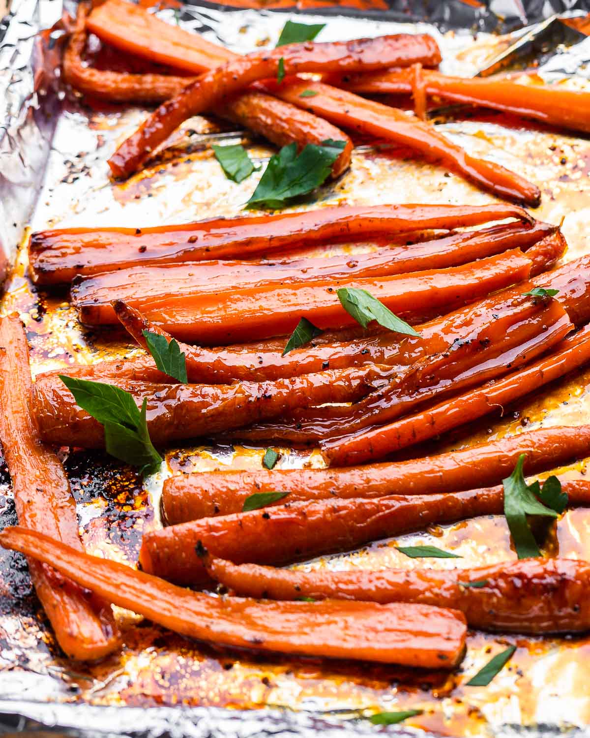 Foil lined baking sheet with glazed maple carrots.