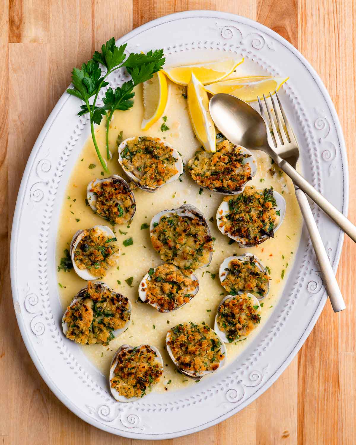 Overhead shot of cooked clams oreganata in oval plate.