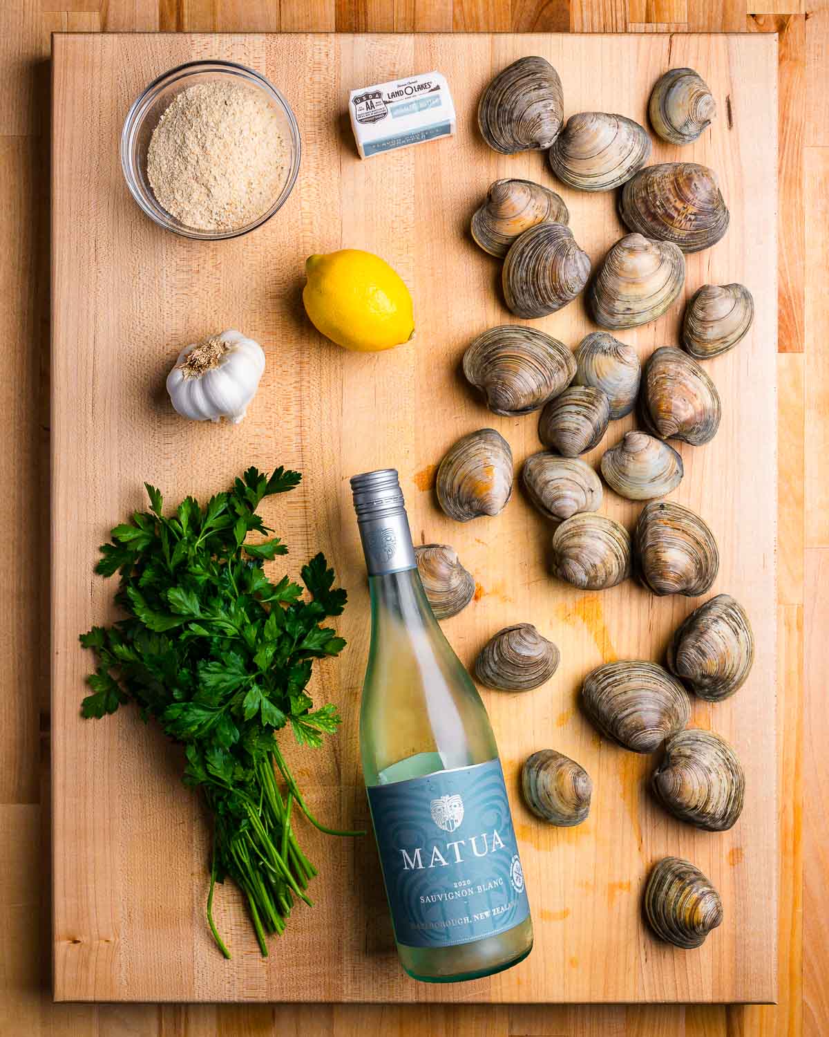 Ingredients shown: breadcrumbs, butter, Littleneck clams, lemon, garlic, parsley, and white wine.