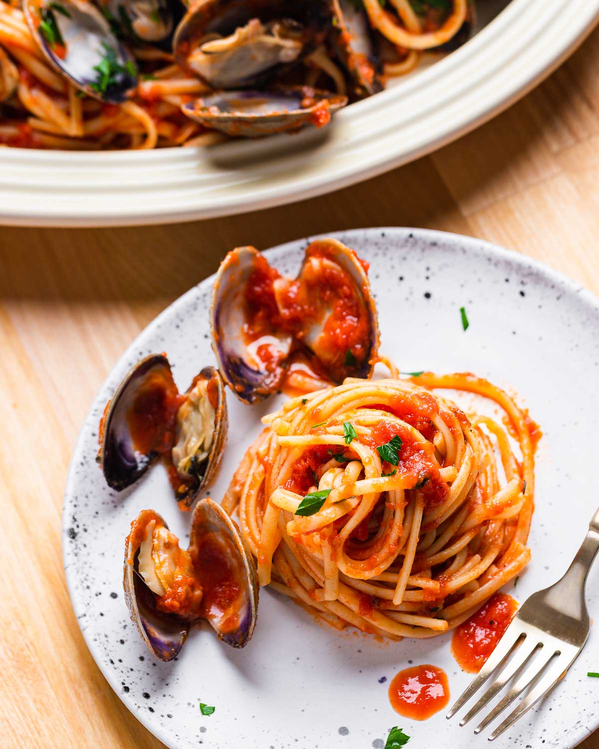 Small plate with linguine and 3 clams.