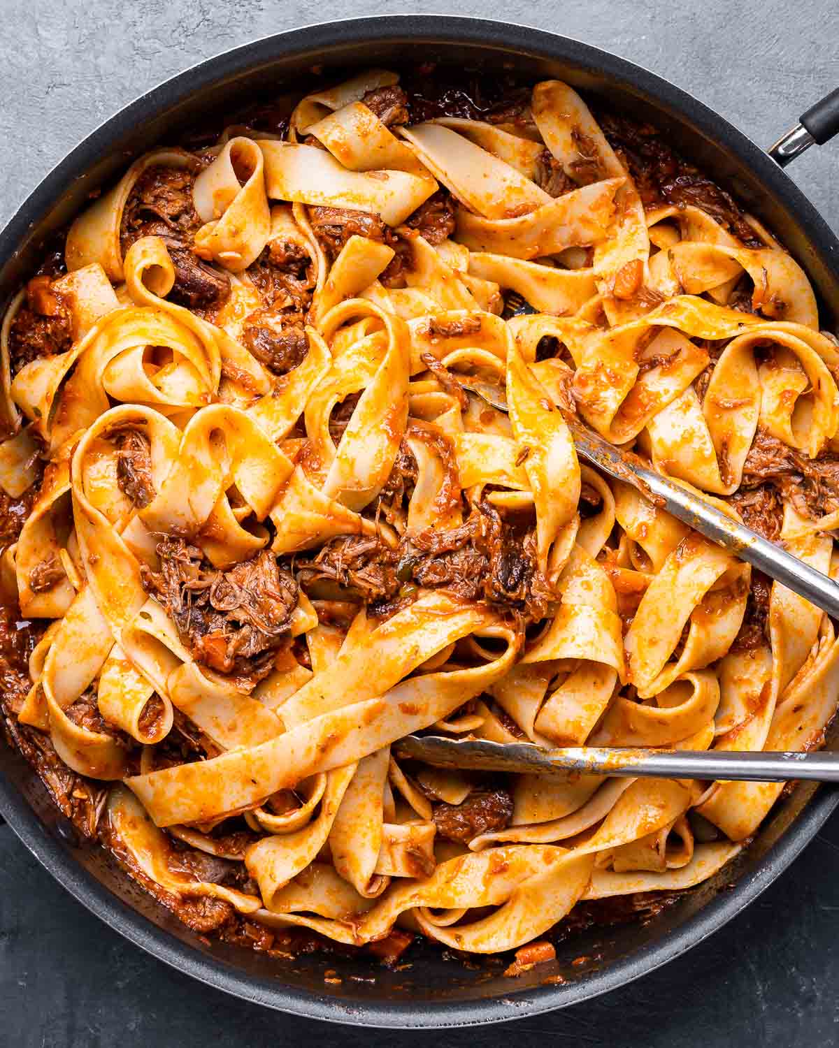 Large pan of pappardelle pasta with short rib ragu.