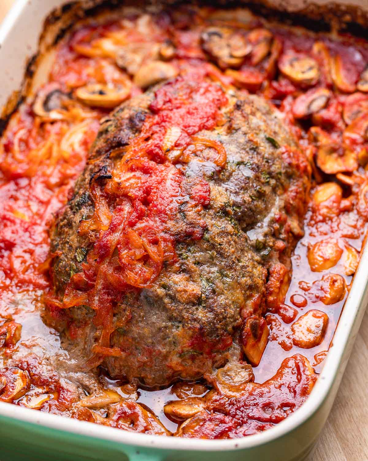 Full meatloaf in green baking dish.
