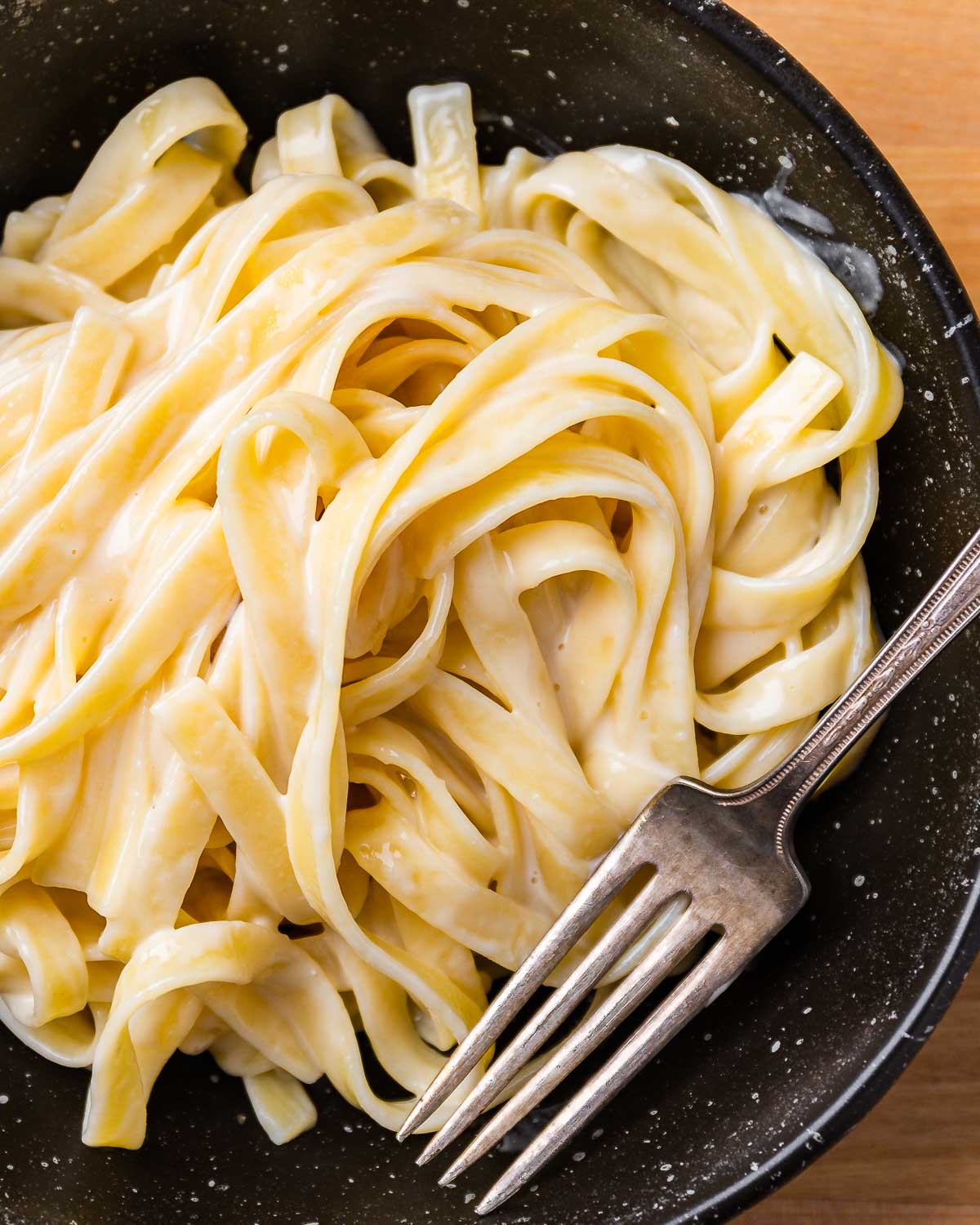 Black bowl with fettuccine alfredo.