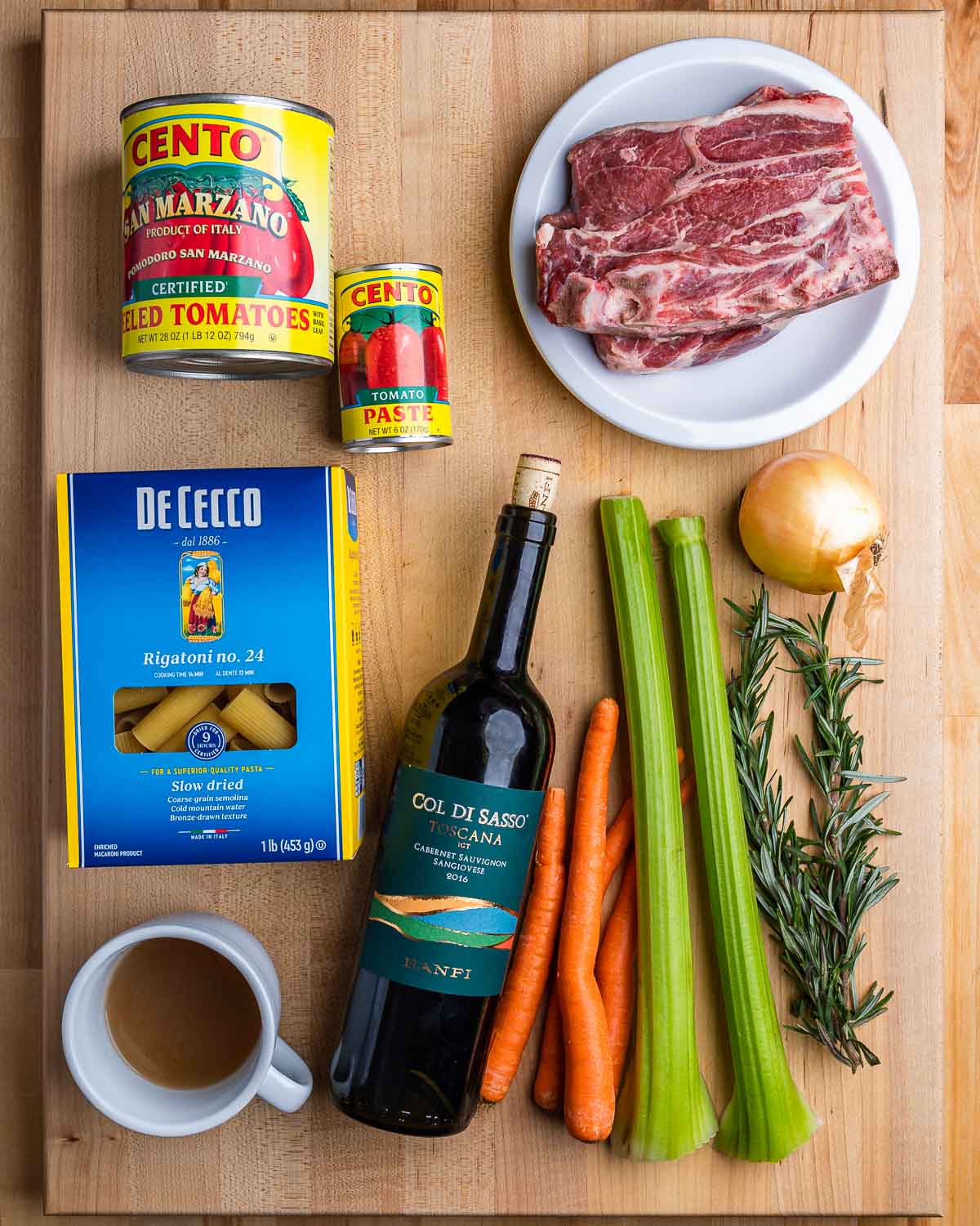 Ingredients shown: tomatoes, lamb shoulder, rigatoni, beef stock, red wine, carrots, celery, onion, and rosemary.