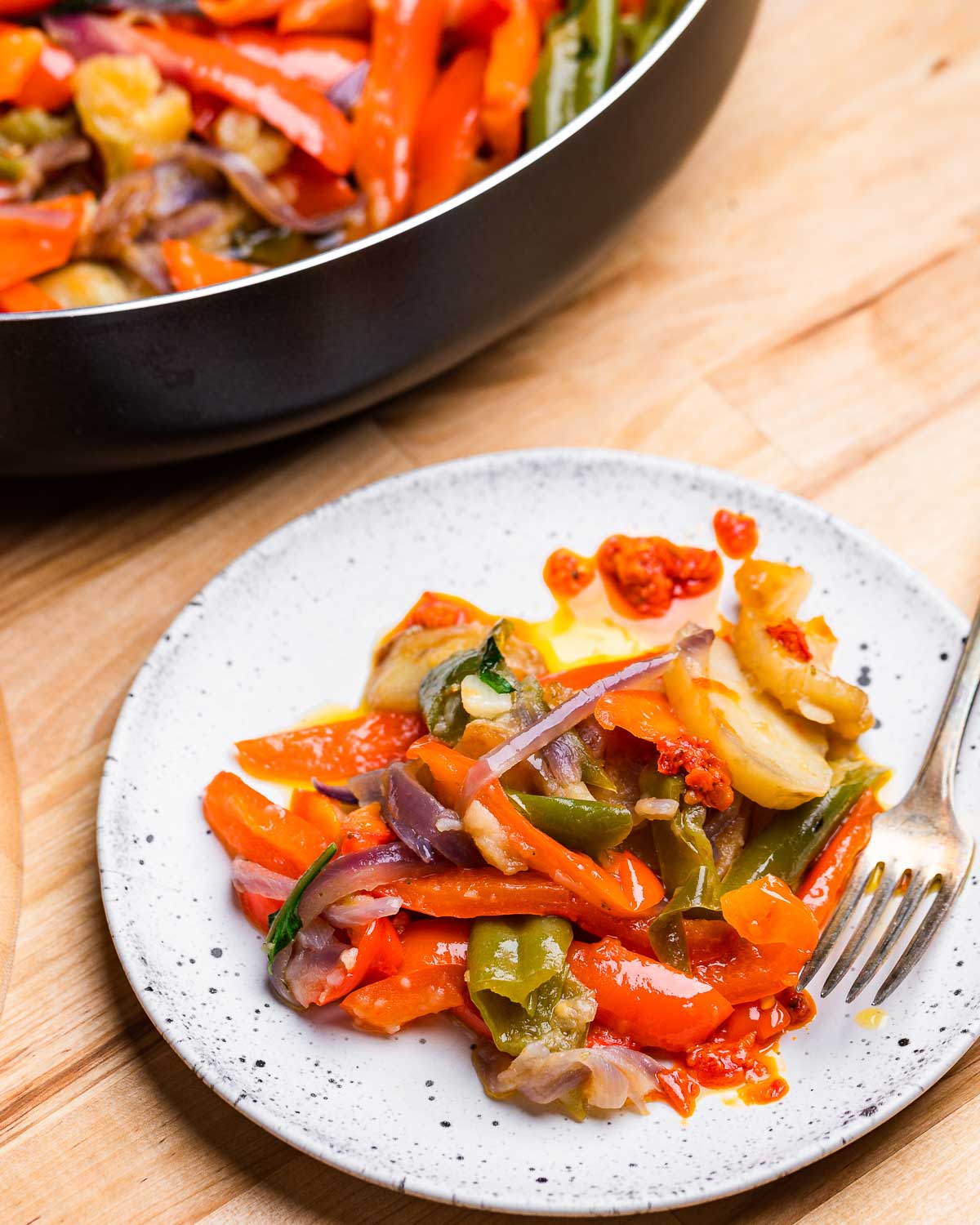 White plate with potatoes and peppers.