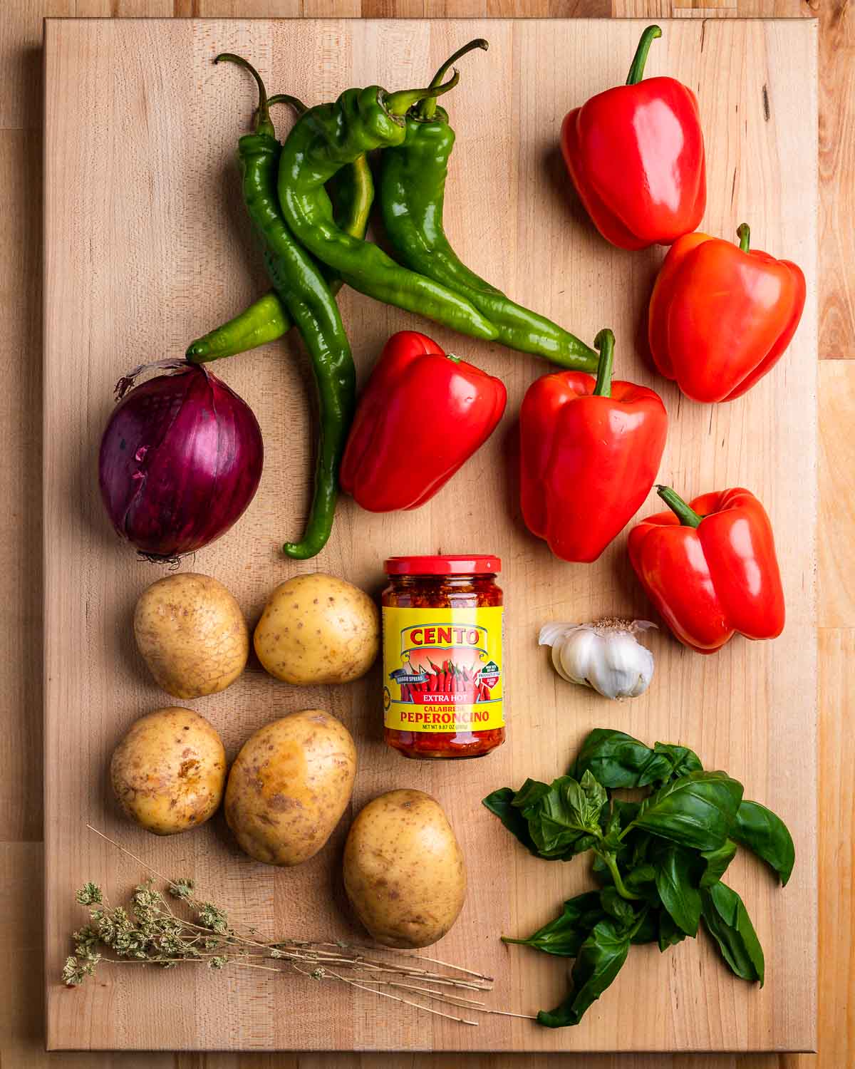 Ingredients shown: assorted peppers, red onion, potatoes, Calabrian chili paste, oregano, garlic, and basil.