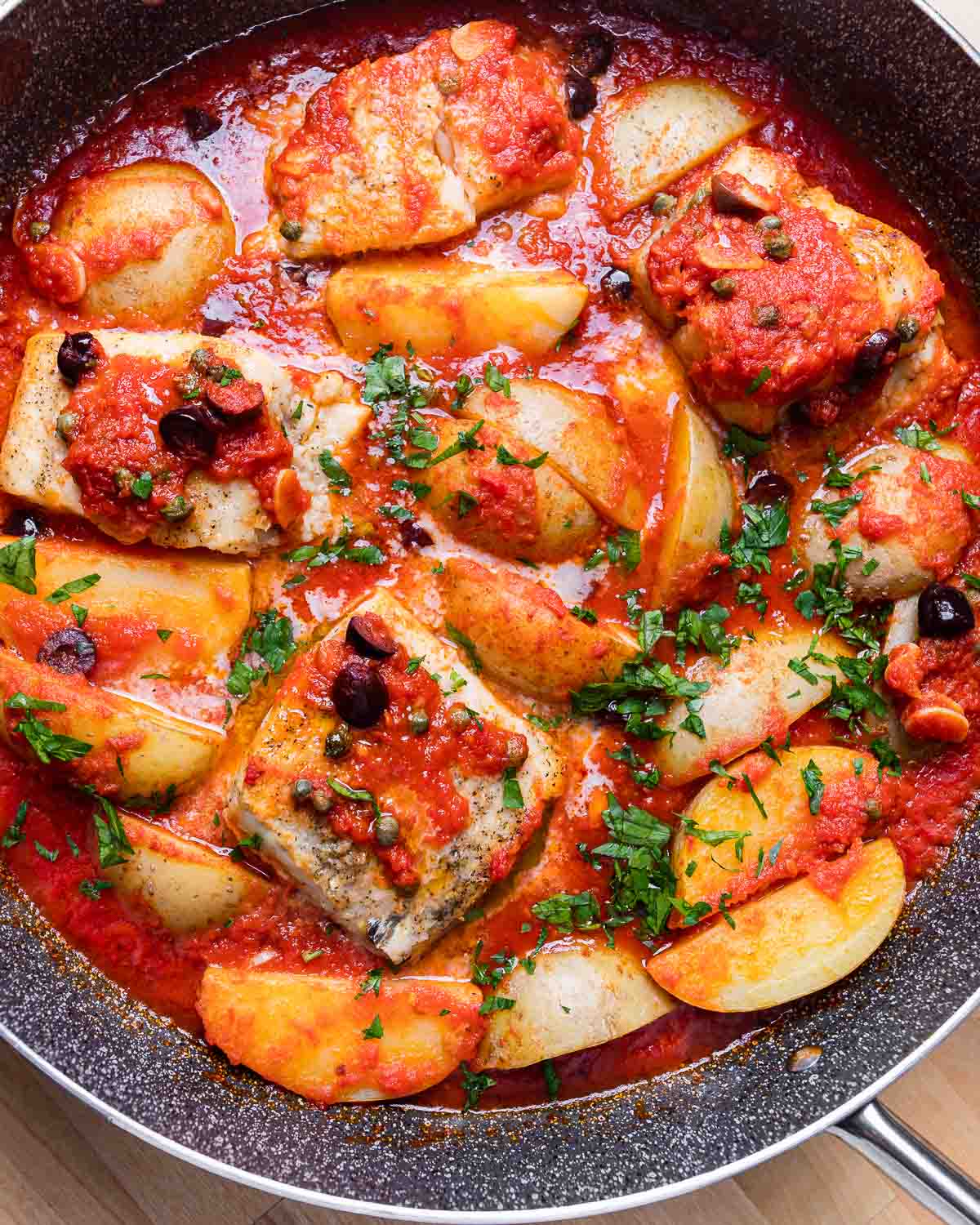 Overhead shot of baccala anna Napoletana in grey saute pan.