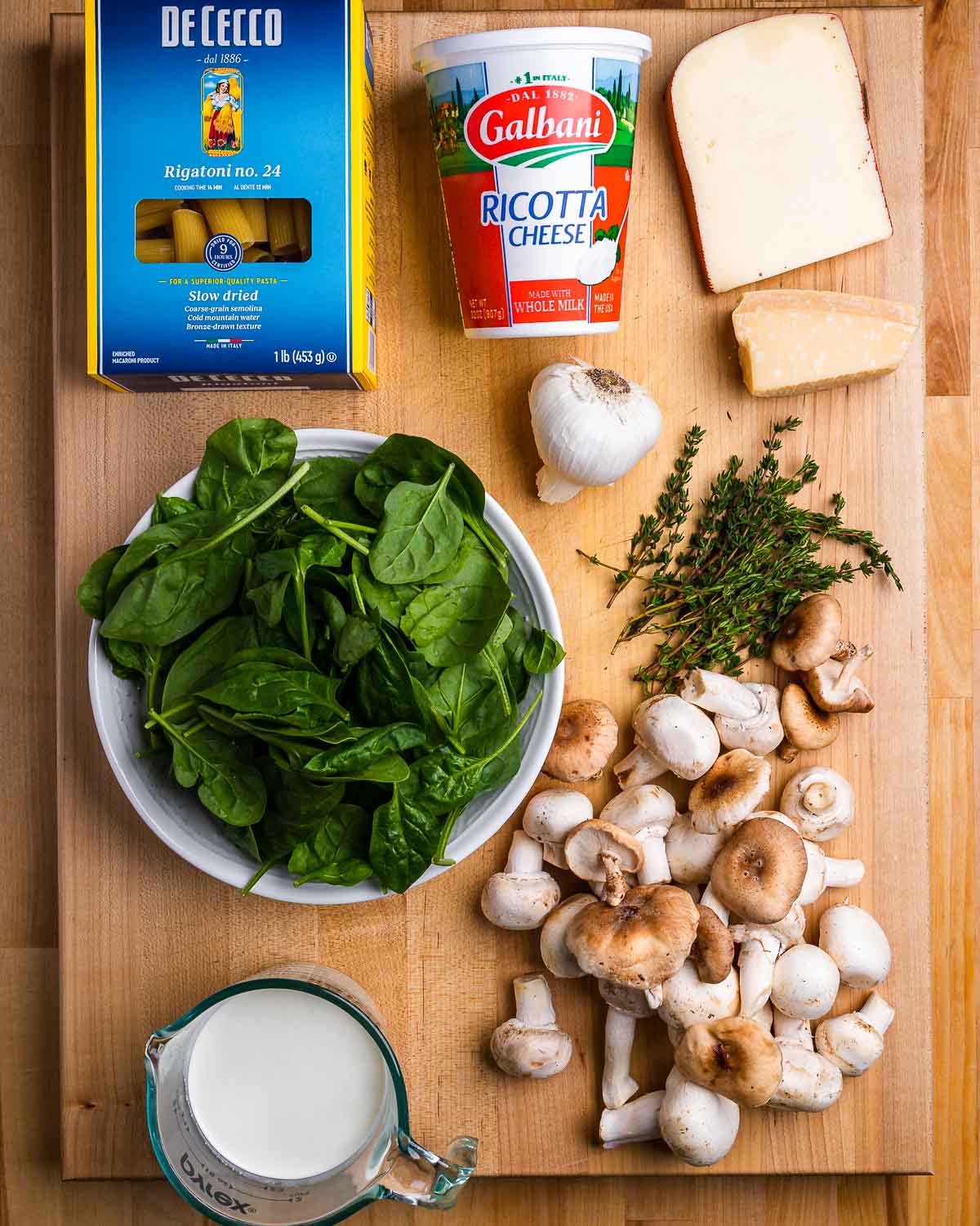 Ingredients shown: rigatoni, ricotta, fontina, garlic, parmesan, spinach, thyme, mushrooms, and cream.