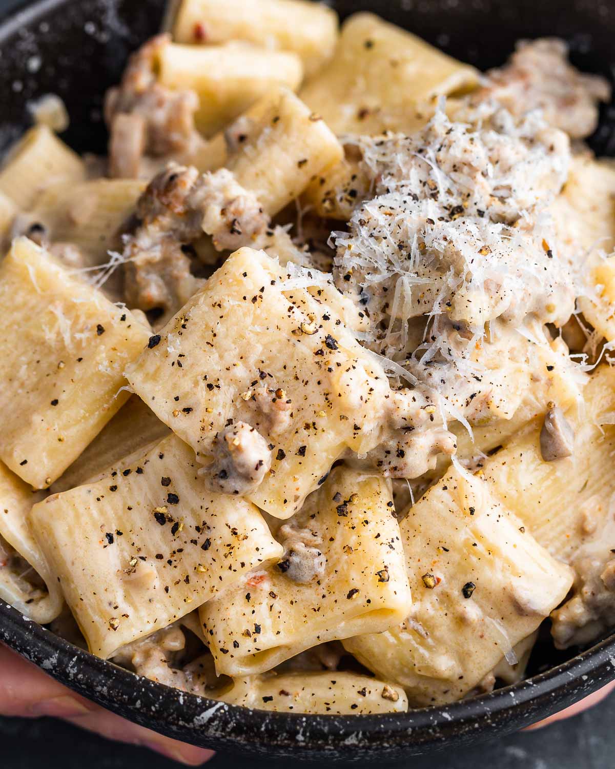 Pasta alla Norcina held in black bowl.