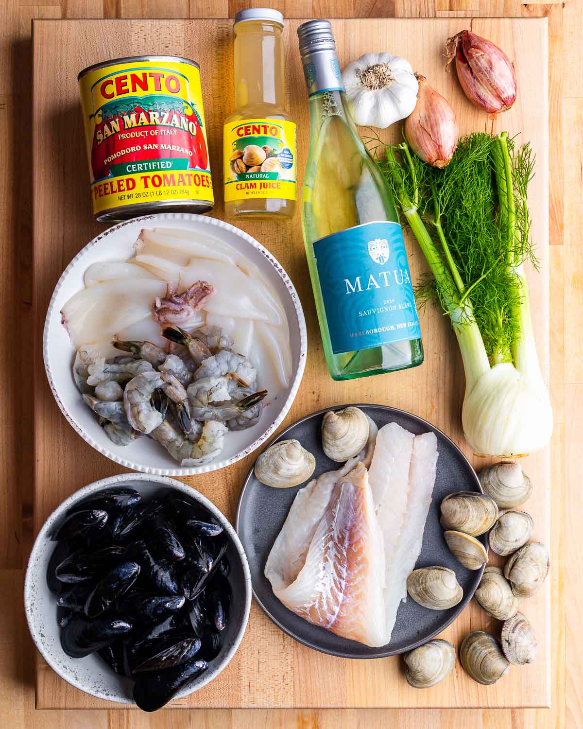 Ingredients shown: canned plum tomatoes, clam juice, wine, garlic, shallots, fennel, mussels, shrimp, calamari, fish, and clams.