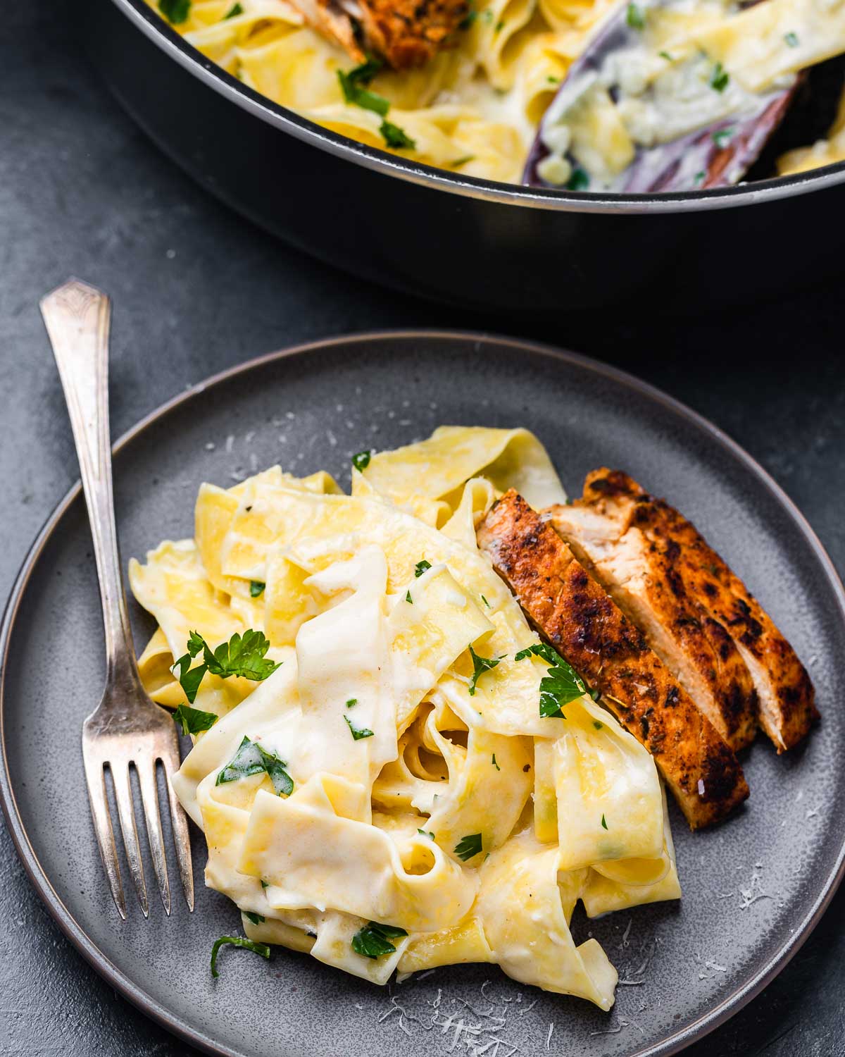 Grey plate with chicken alfredo pappardelle.