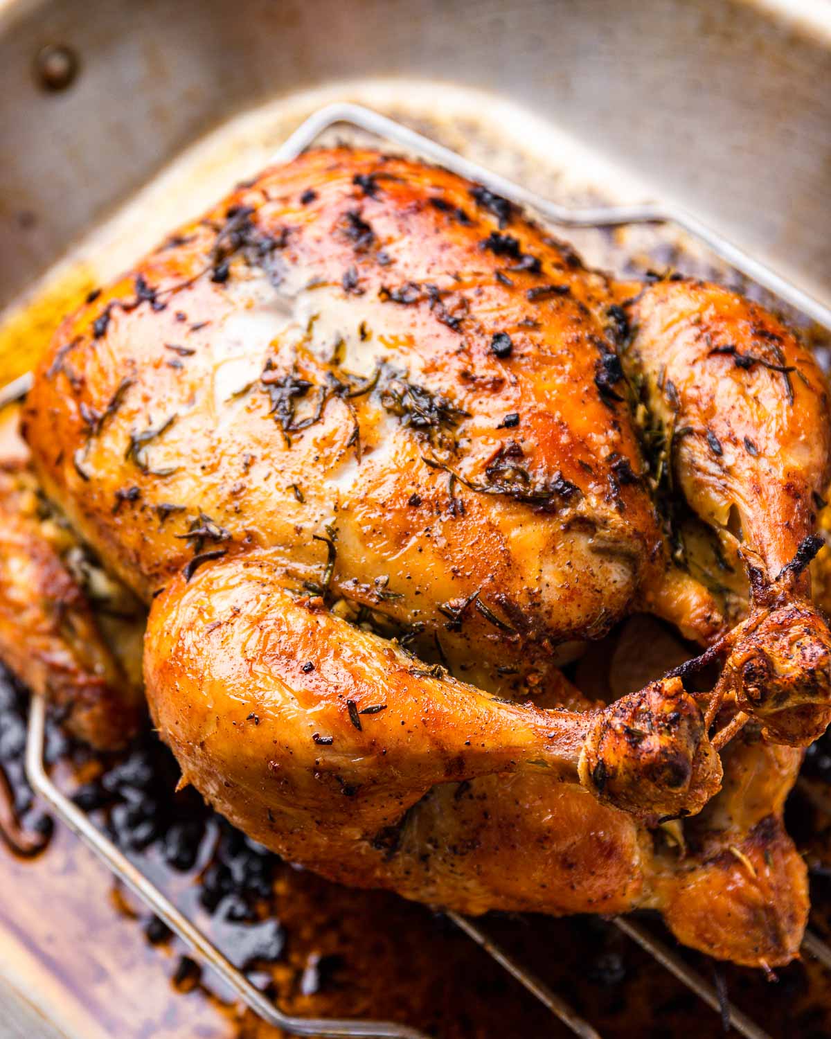 Garlic butter roast chicken in roasting pan.