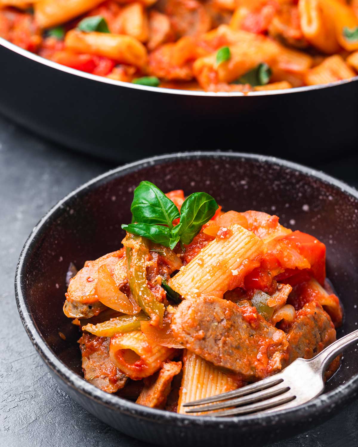 Black bowl with sausage and peppers rigatoni.