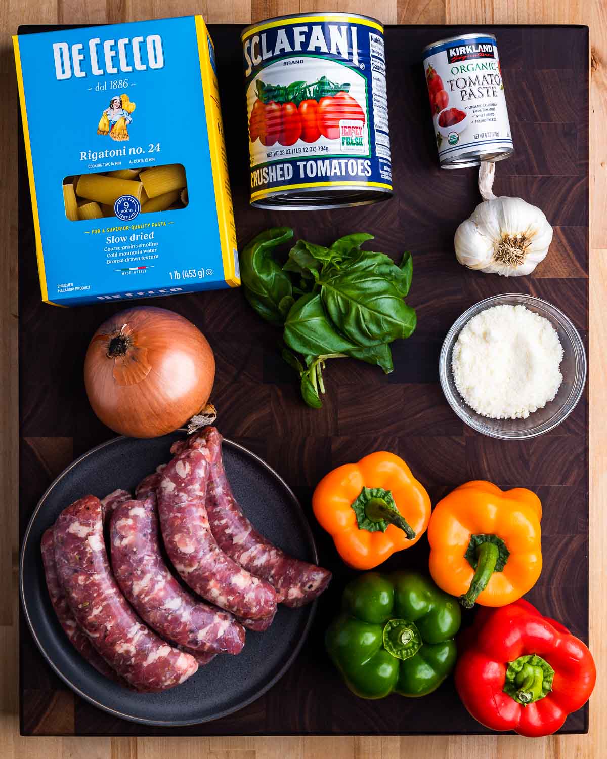 Ingredients shown: rigatoni, can tomatoes, basil, garlic, Pecorino, onion, sausage, and bell peppers.