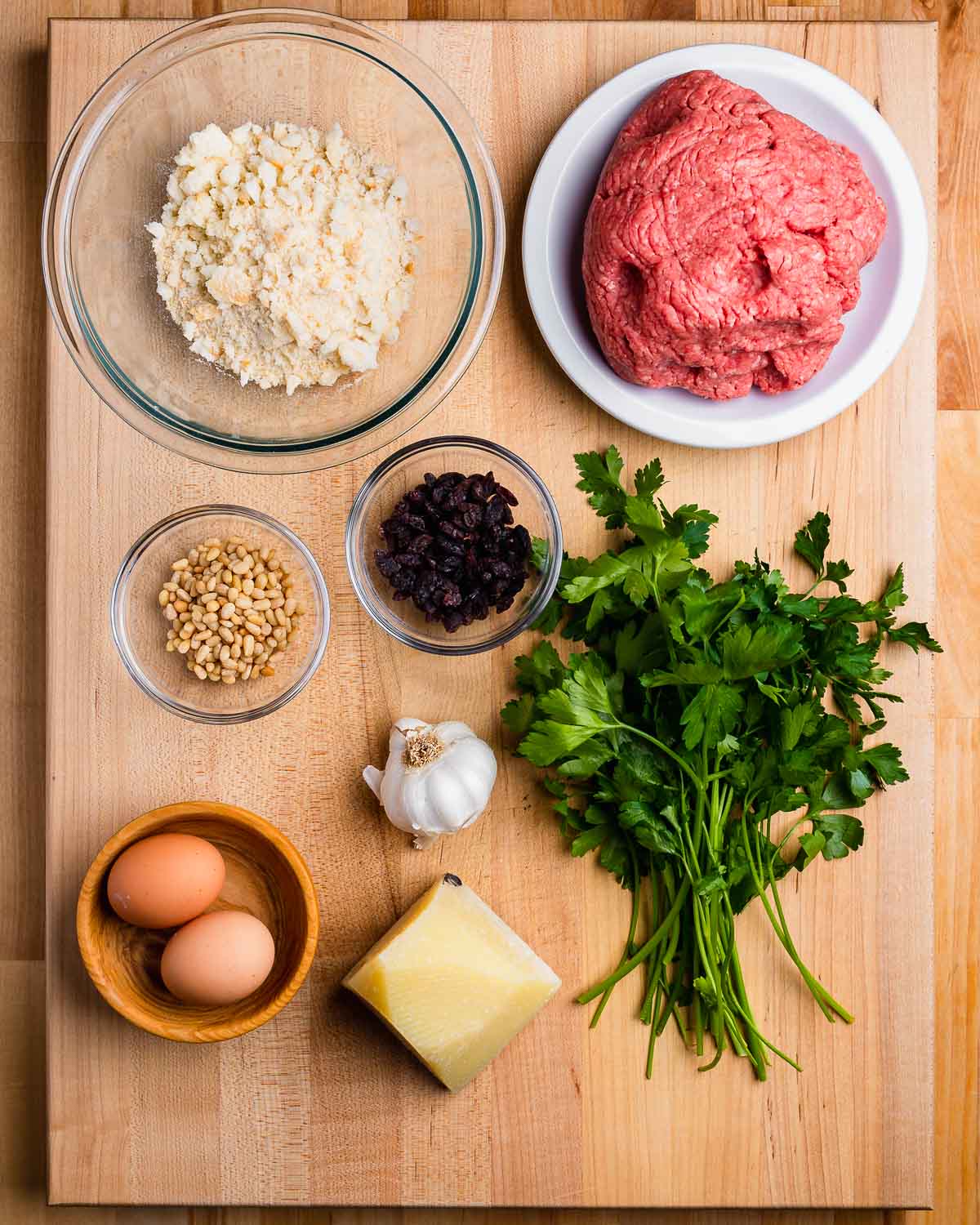 Ingredients shown: Breadcrumbs, ground beef, pine nuts, raisins, parsley, garlic, eggs, and Pecorino.
