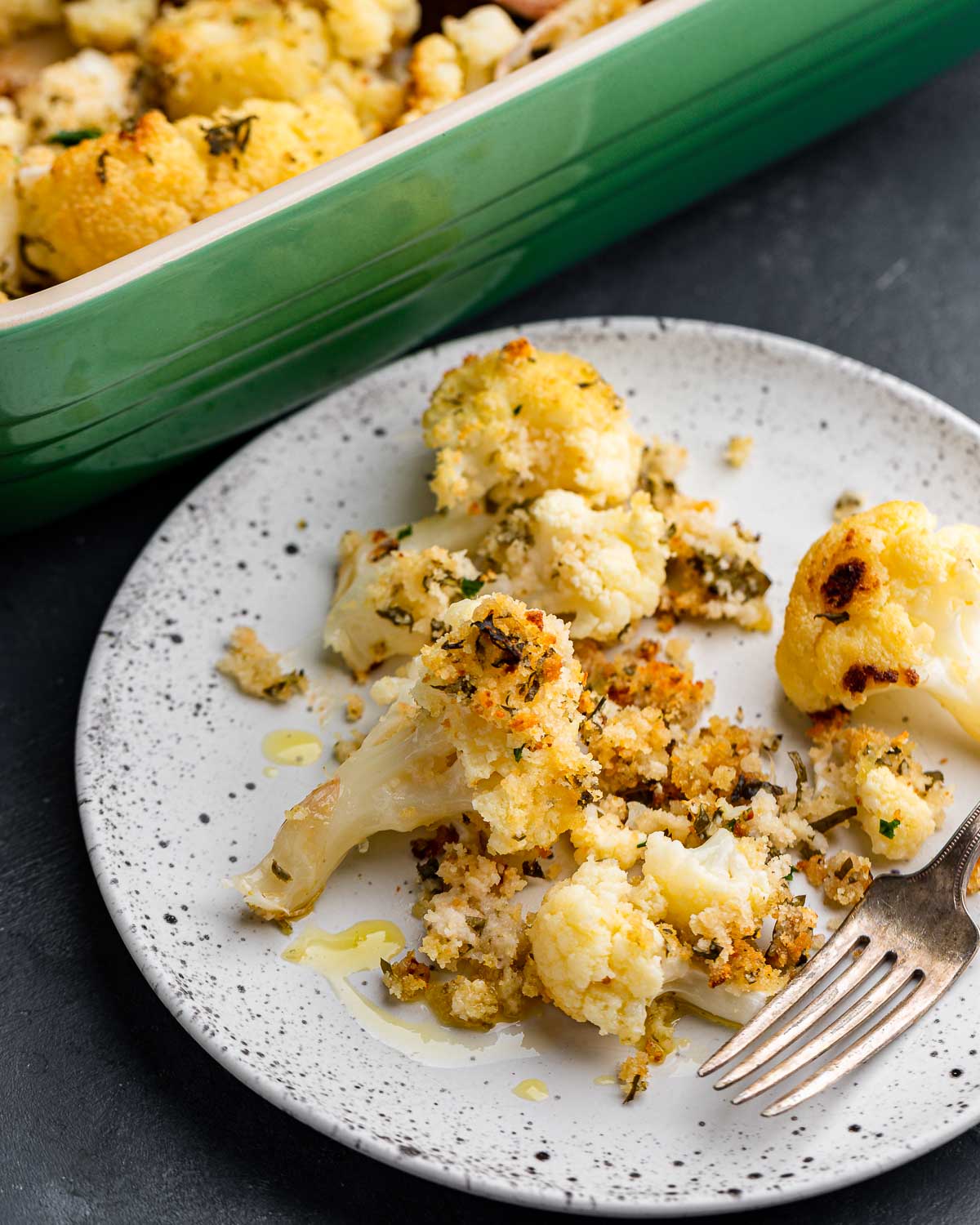 White plate and fork with baked cauliflower and breadcrumbs.