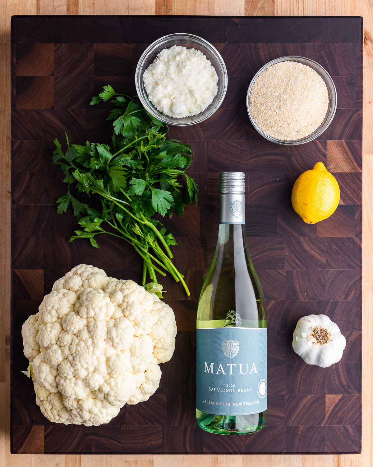 Ingredients shown: Pecorino, breadcrumbs, parsley, cauliflower, white wine, lemon, and garlic.