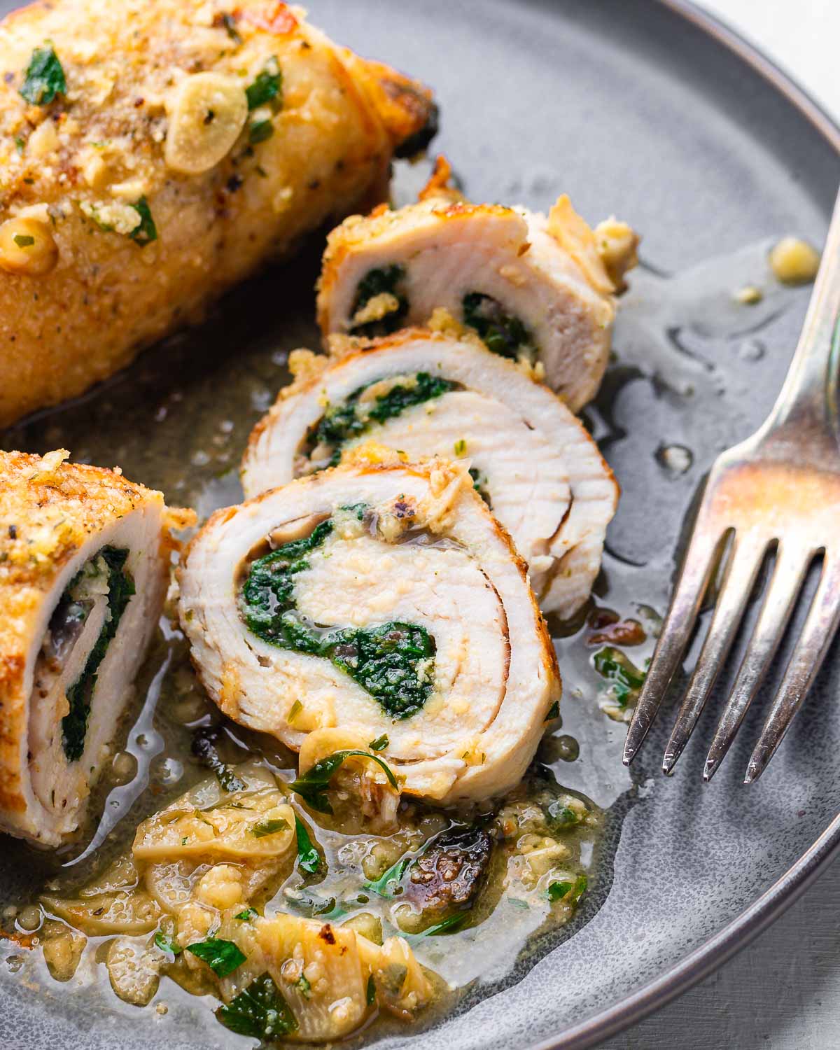 Grey plate with sliced chicken involtini.