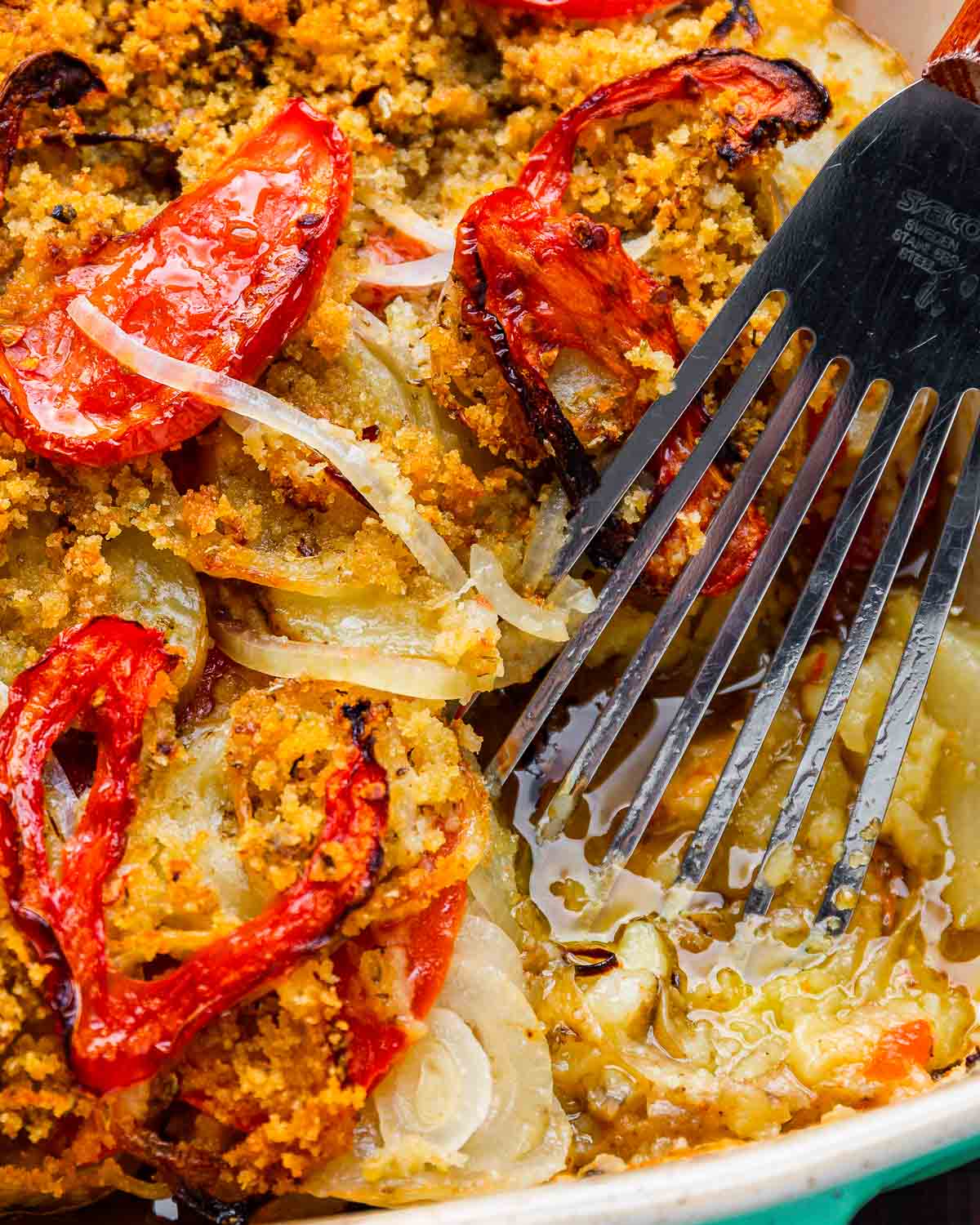 Italian potato casserole with spatula in baking dish.