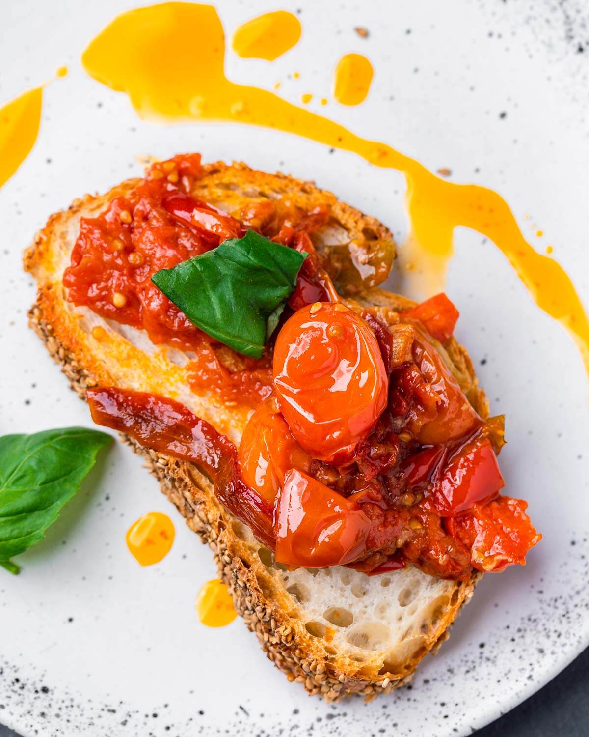 Cherry pepper spread on toasted Italian bread in white plate.