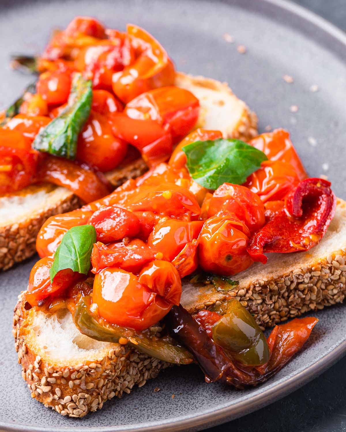 Cherry pepper spread on toasted bread pieces in grey plate.