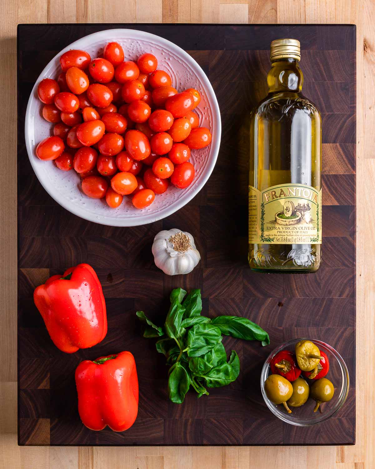 Ingredients shown: cherry tomatoes, olive oil, bell peppers, garlic, basil, and cherry peppers.