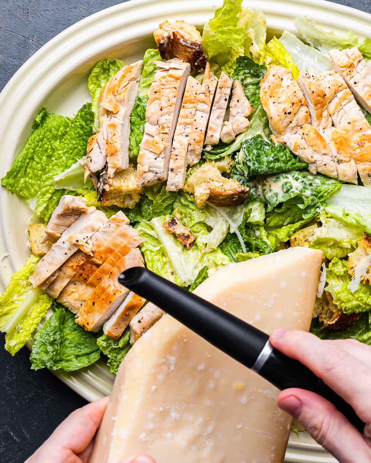 Shaving parmesan cheese on top of salad.