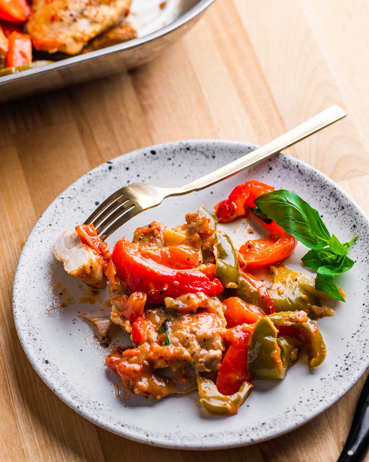 Chicken and peppers in white plate with fork.