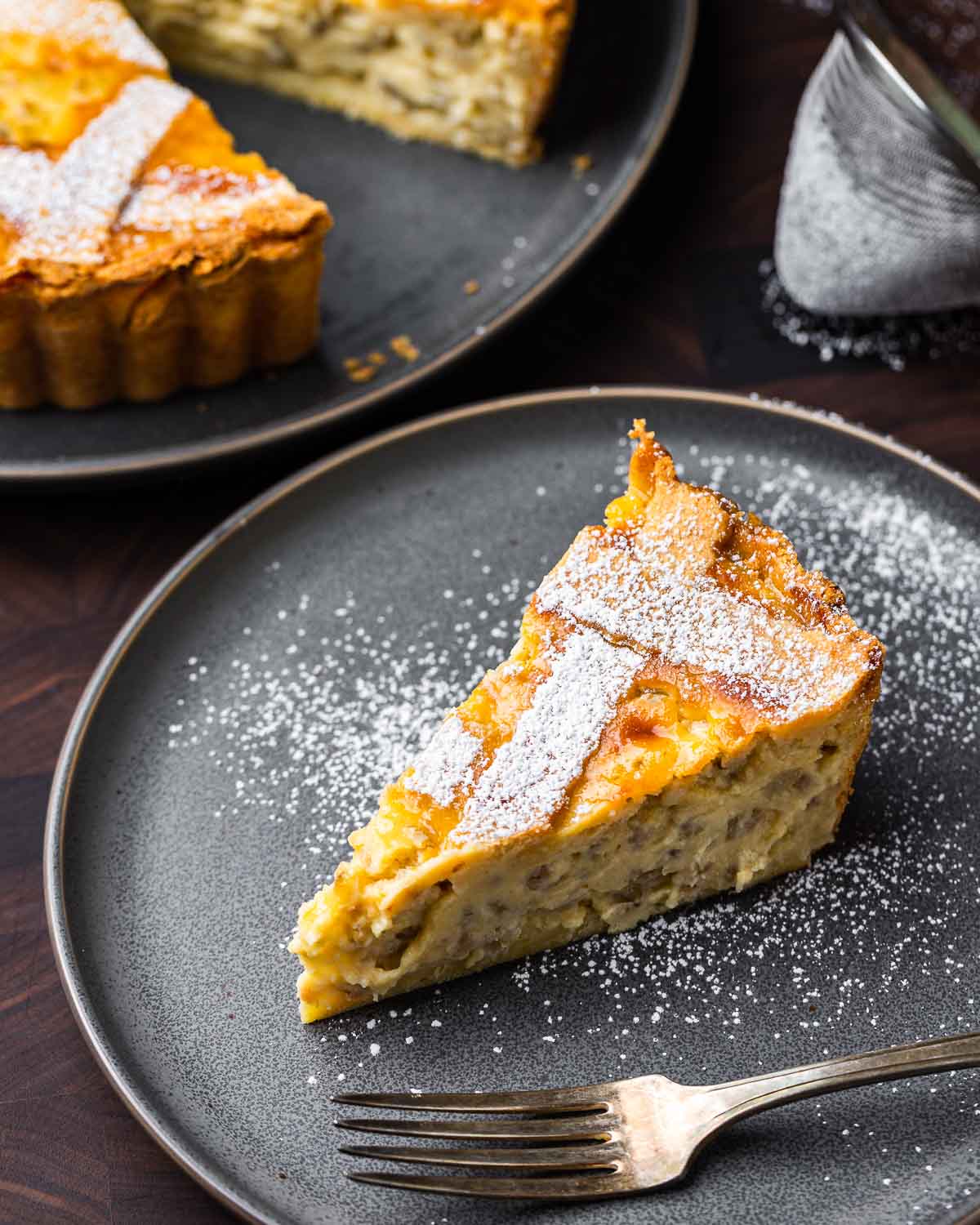 Slice of pastiera Napoletana in grey plate.