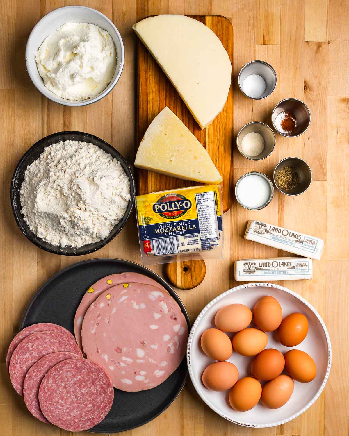 Ingredients shown: cheeses, flour, seasonings, butter, cold cuts, and eggs.