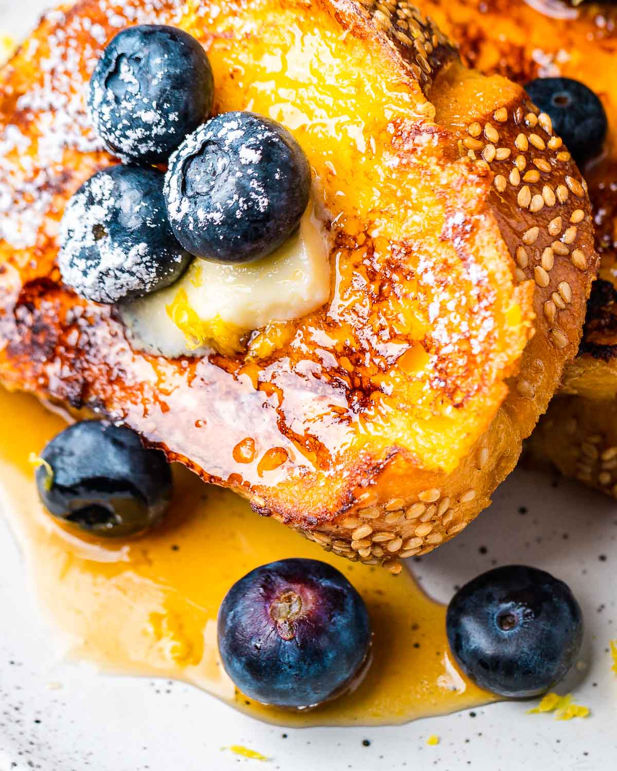 Lemon blueberry French toast with butter and syrup.