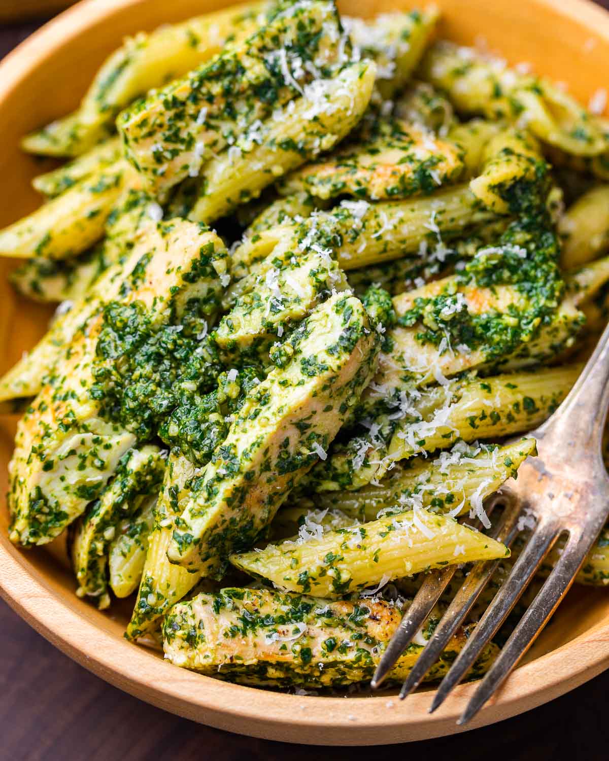 Chicken pesto pasta salad in wooden bowl.