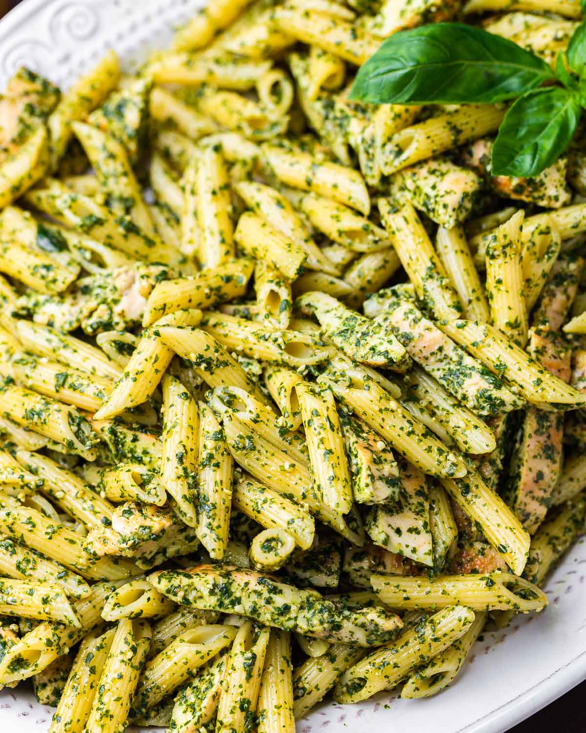 Chicken pesto penne salad in white platter.