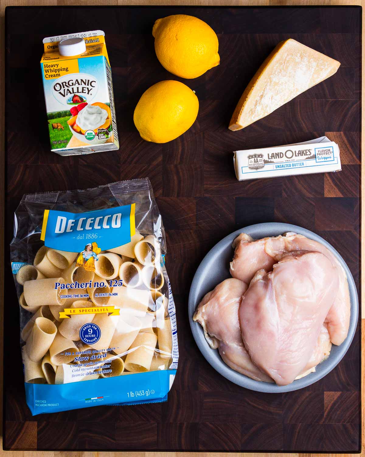 Ingredients shown: heavy cream, lemons, Parmigiano Reggiano, butter, pasta, and chicken breasts.