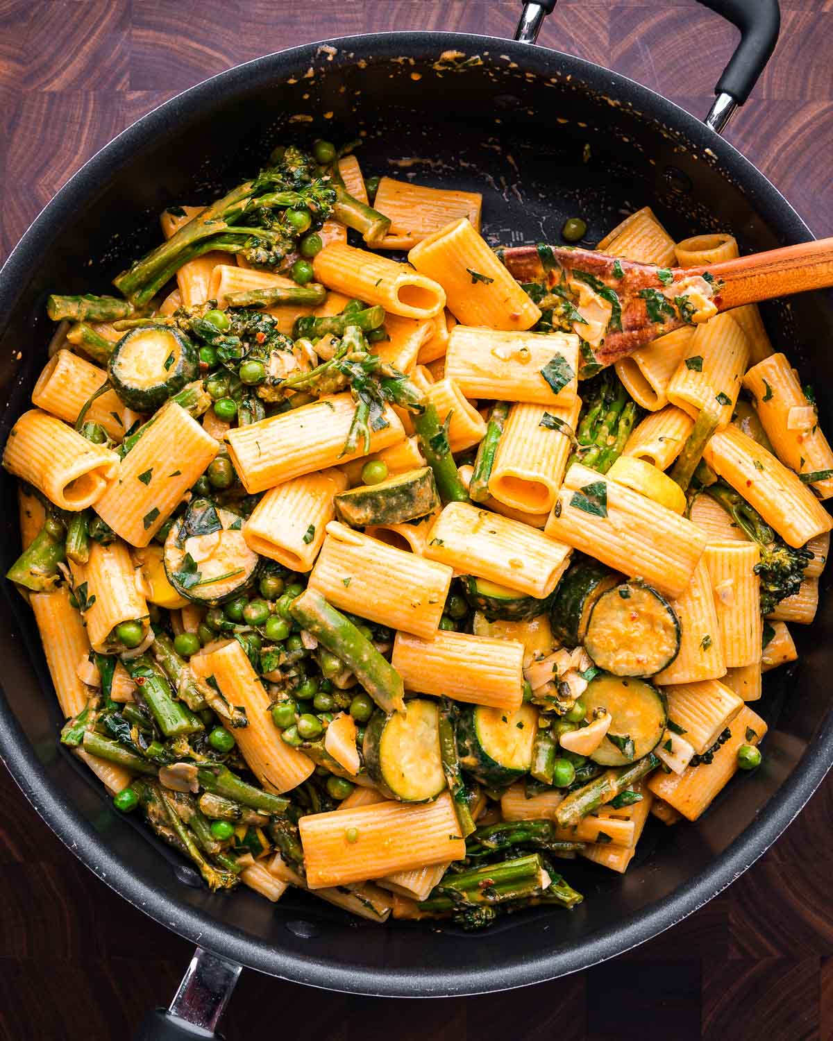 Rigatoni primavera in large pan on walnut cutting board.