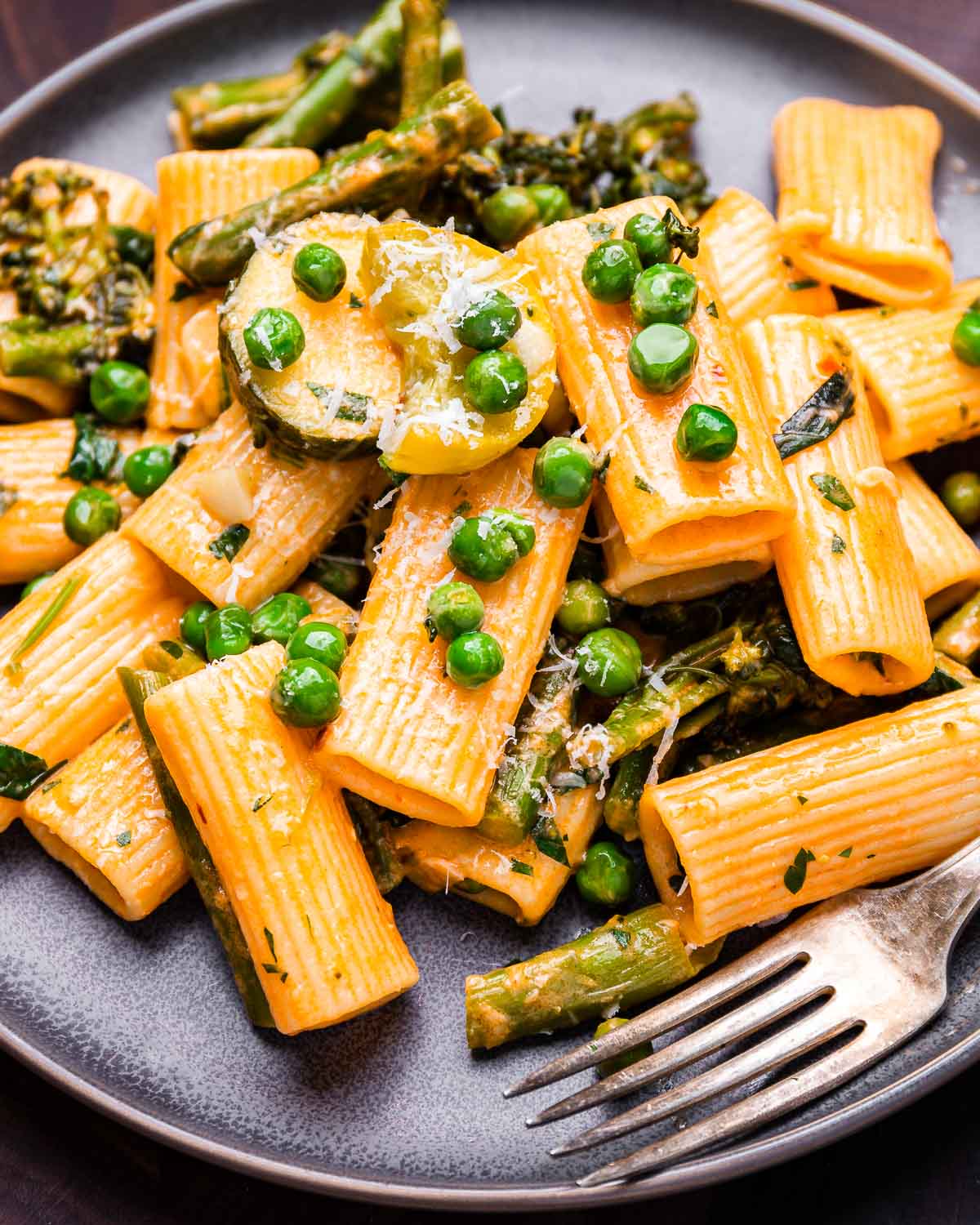 Rigatoni primavera in grey plate with fork.