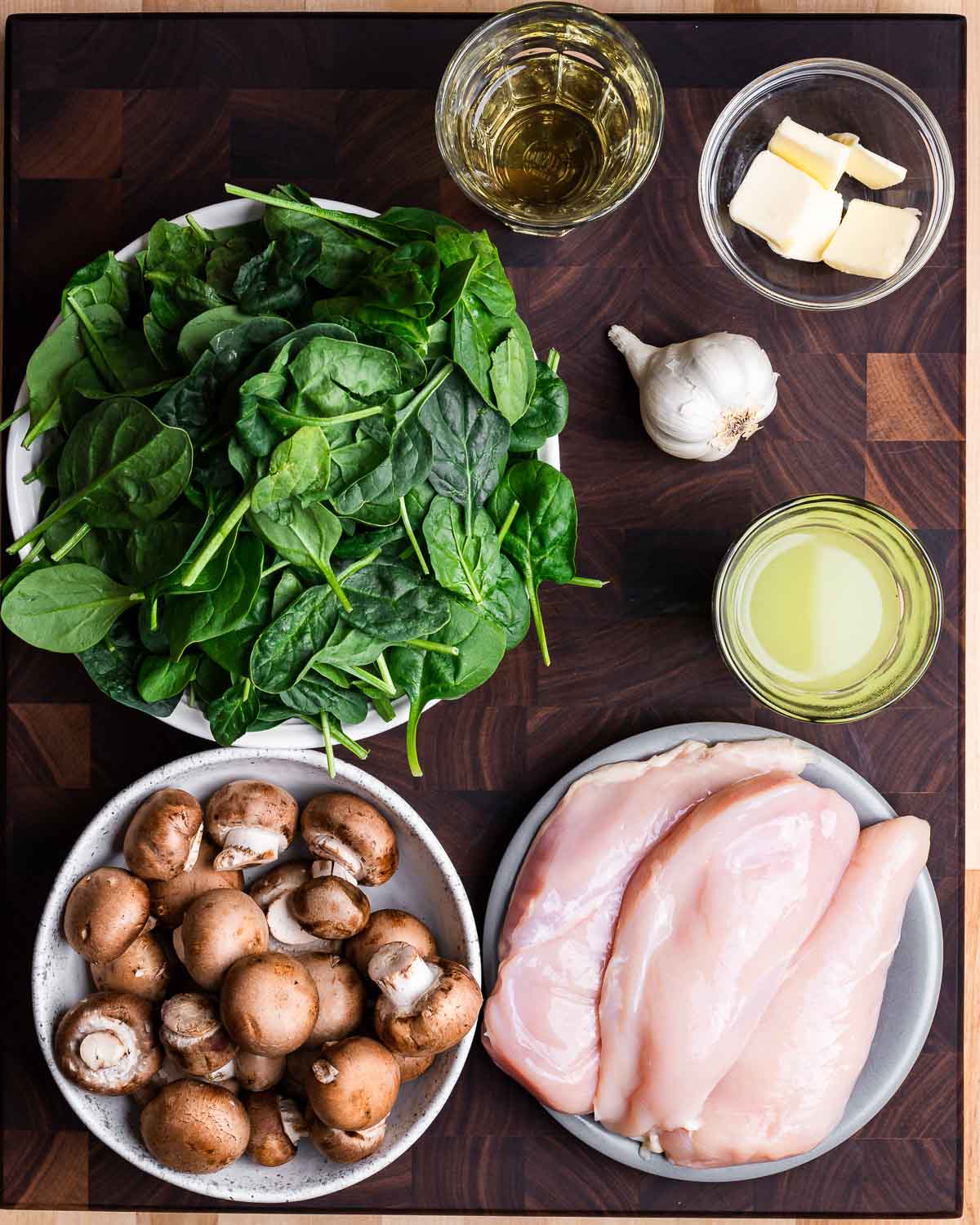 Ingredients shown: White wine, butter, spinach, garlic, chicken stock, mushrooms, and chicken breasts.