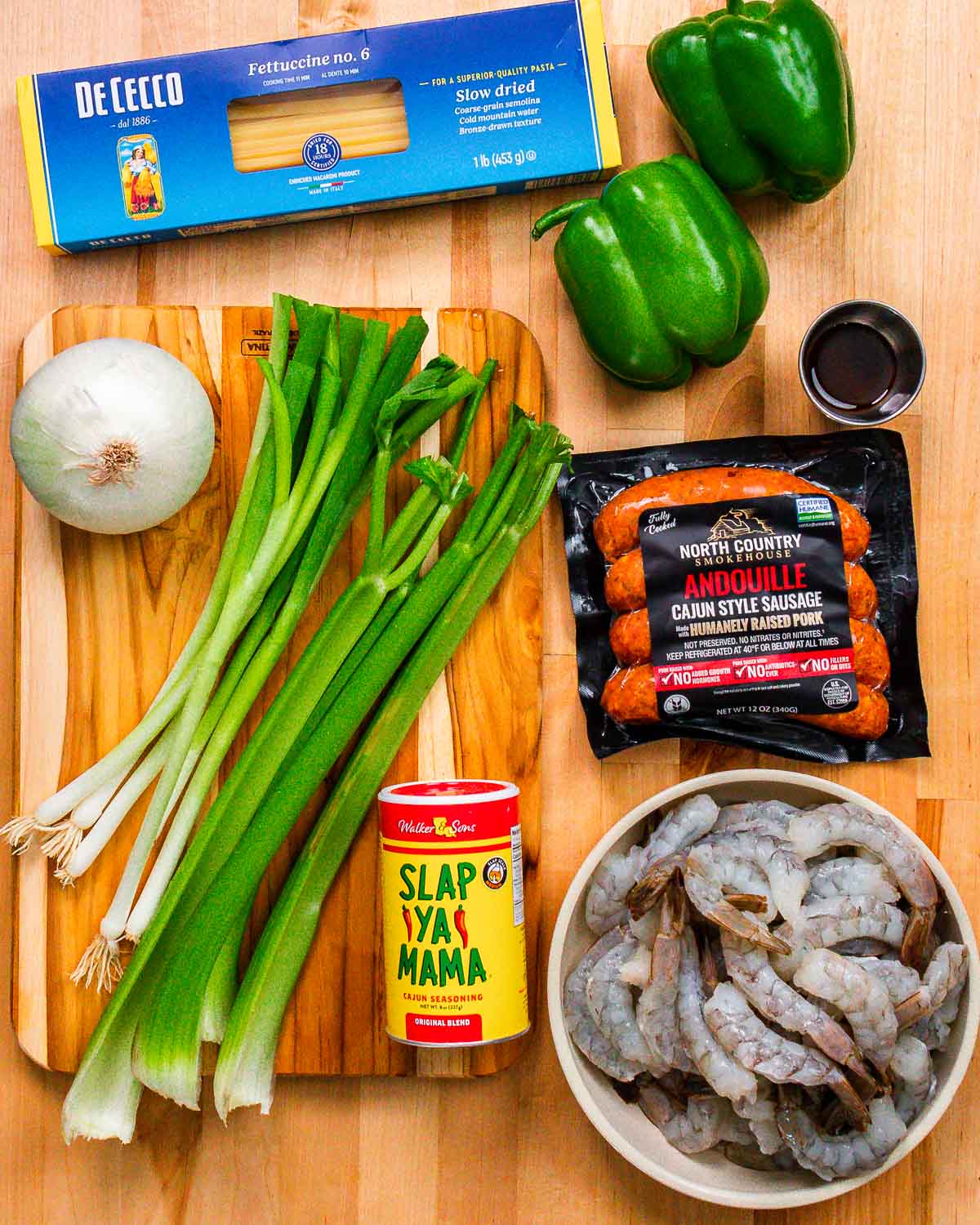 Ingredients shown: pasta, peppers, onion, green onions, celery, Worcestershire sauce, Andouille, Cajun seasoning, and shrimp.
