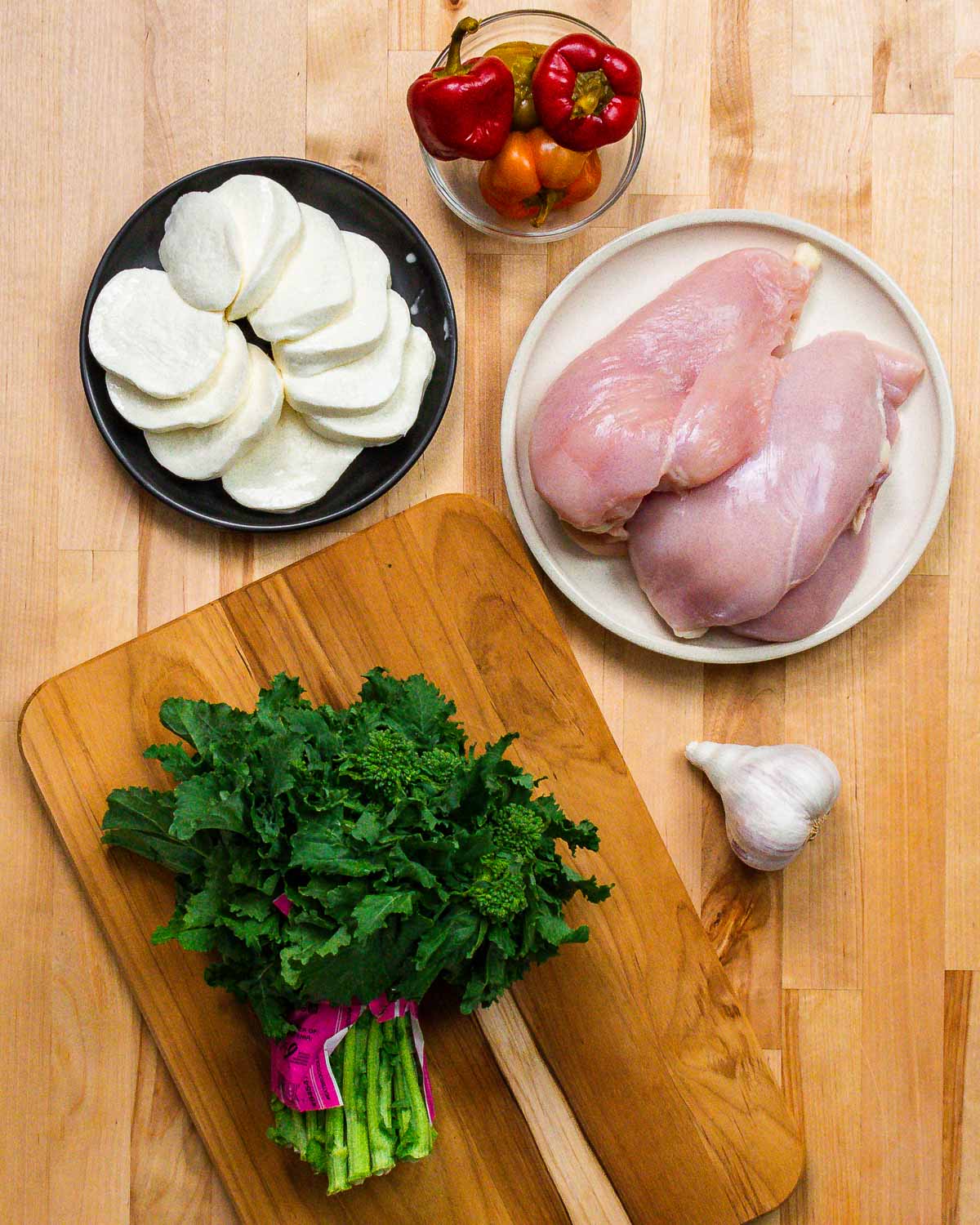 Ingredients shown: mozzarella, cherry peppers, chicken breasts, broccoli rabe, and garlic.