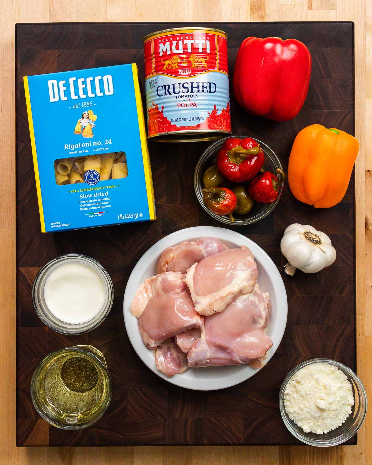 Ingredients shown: rigatoni, tomatoes, bell and cherry peppers, cream, wine, garlic, chicken thighs, and Pecorino.