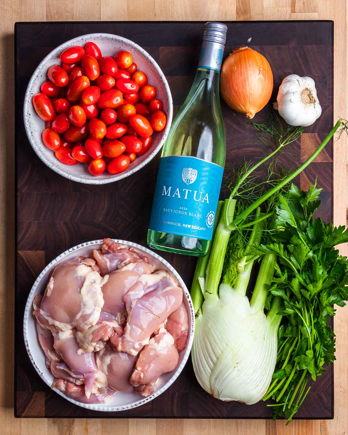 Ingredients shown: cherry tomatoes, white wine, onion, garlic, chicken thighs, and fennel.