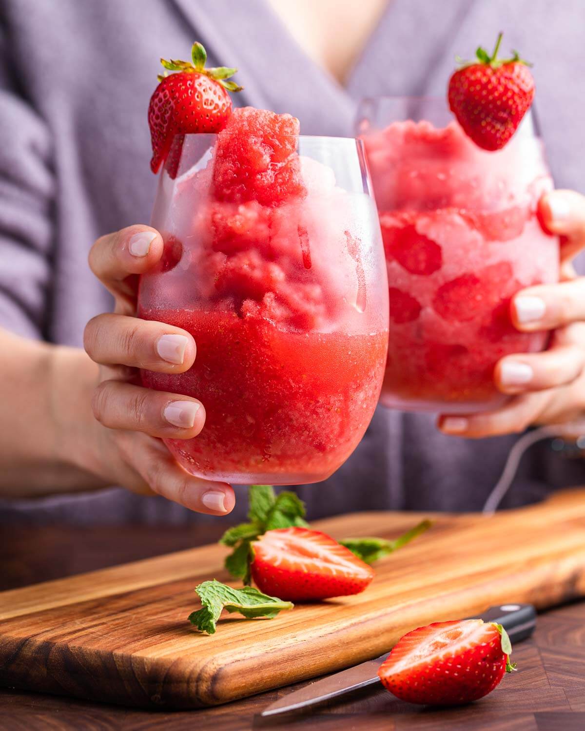 Hands holding two glasses of frosé.