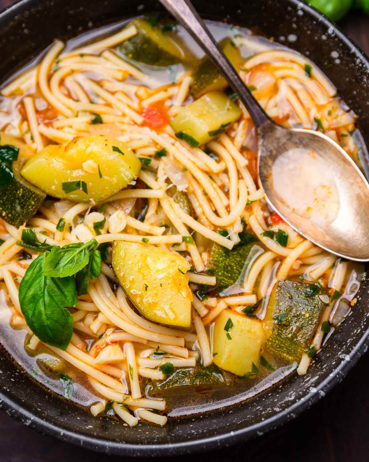 Italian zucchini soup in black bowl.