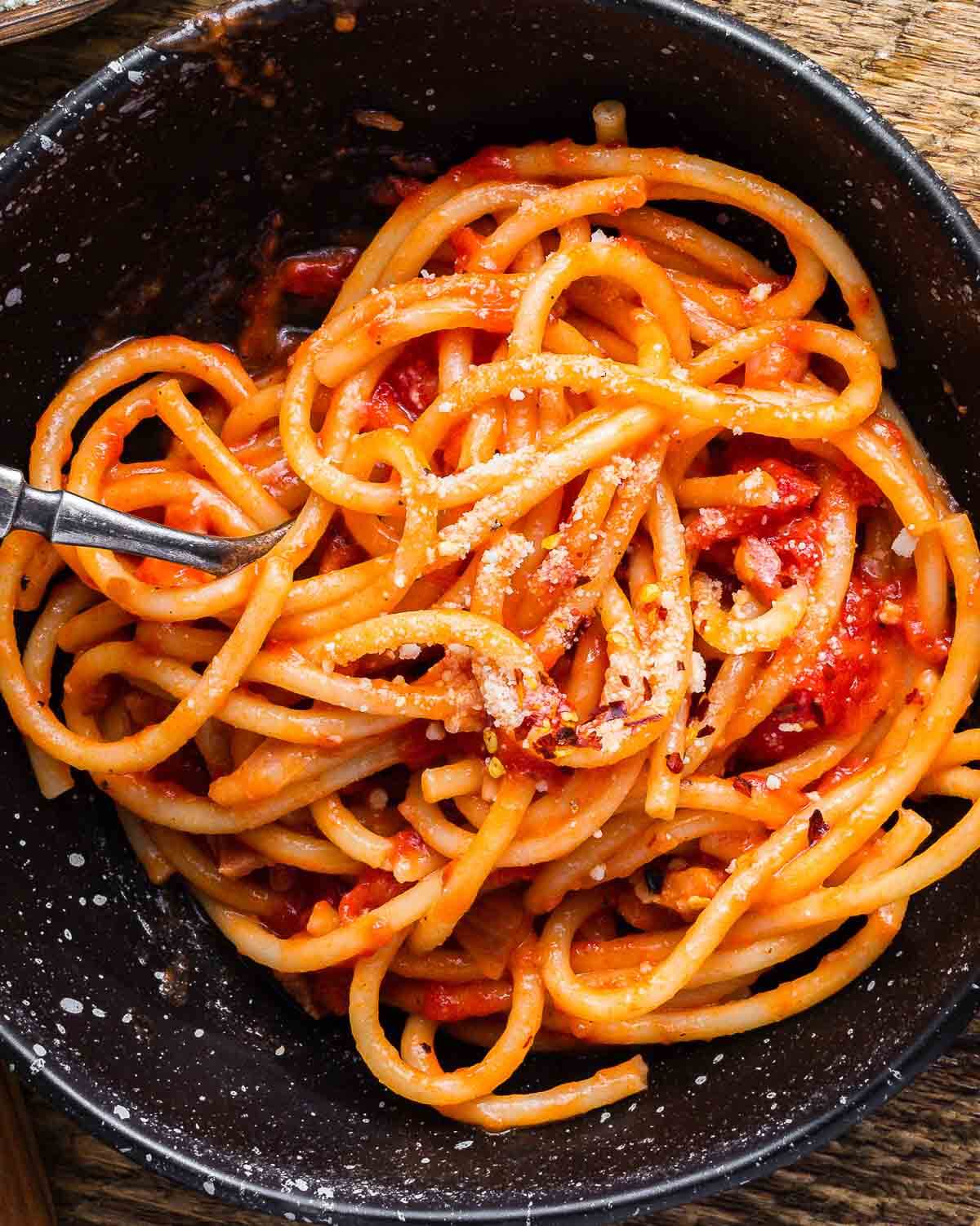 Black bowl with bucatini Amatriciana.