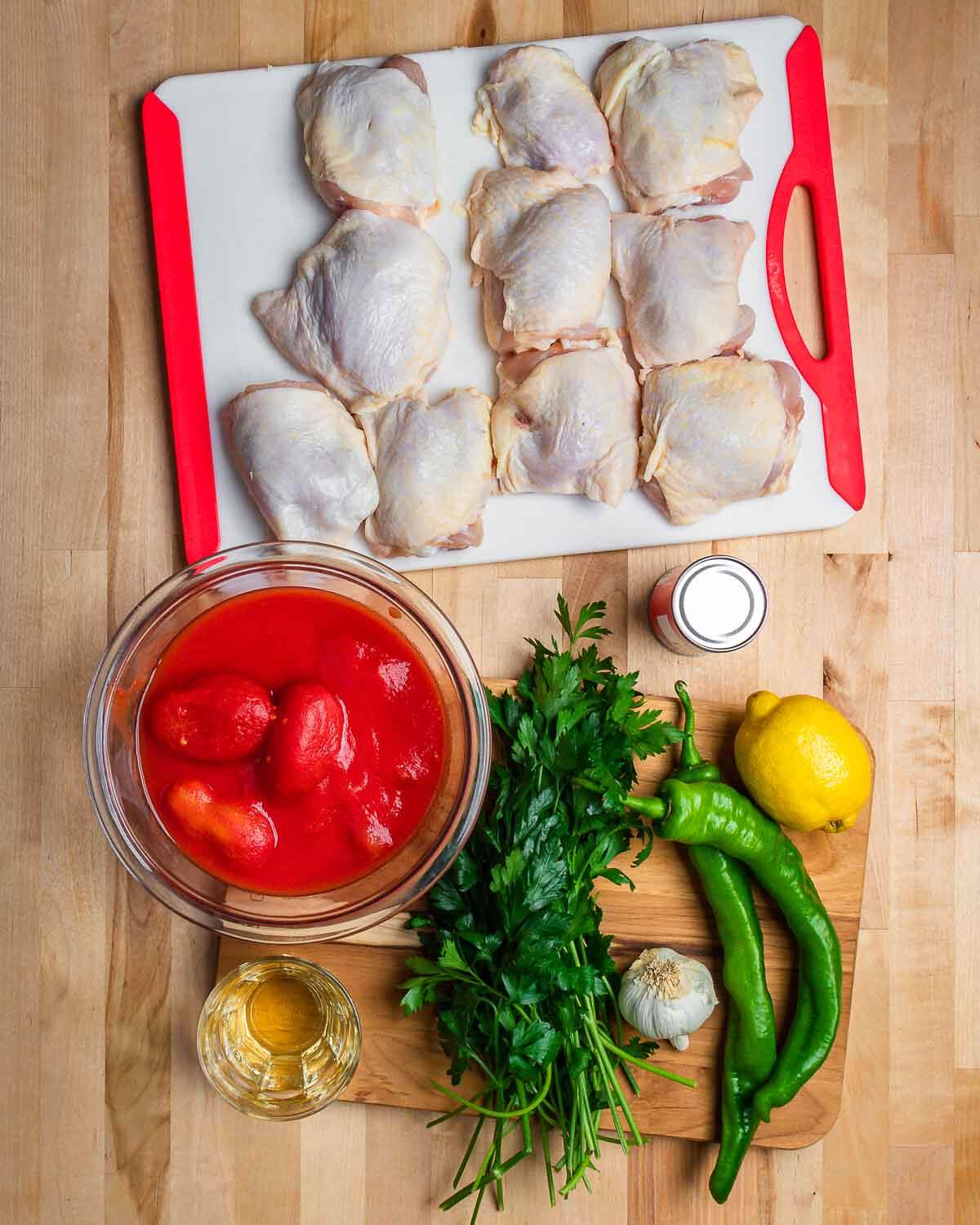 Ingredients shown: chicken thighs, plum tomatoes, wine, parsley, garlic, long hot peppers, lemon, and tomato paste.