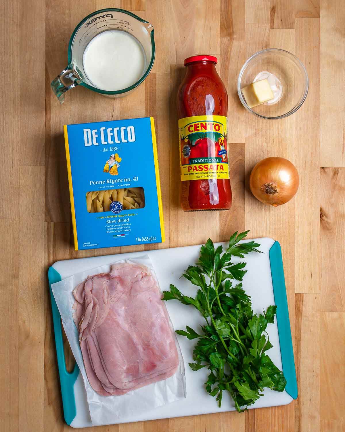 Ingredients shown: cream, penne pasta, passata, butter, onion, ham, and parsley.