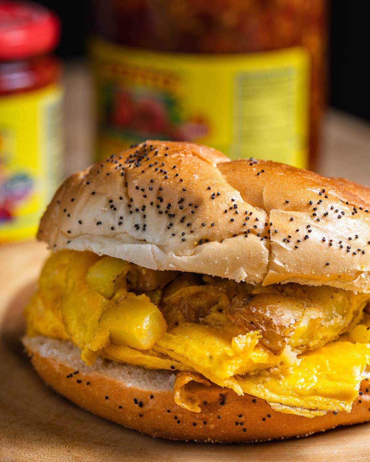 Potato and egg sandwich on wooden board.