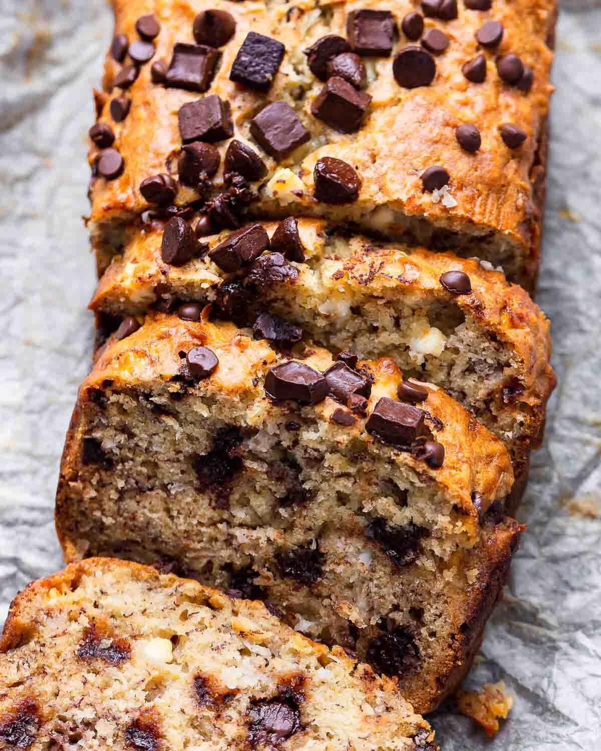 Sliced chocolate chip banana bread on parchment paper.