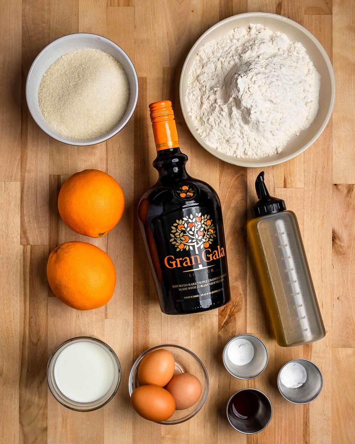 Ingredients shown: sugar, flour, oranges, Gran Gala, olive oil, milk, eggs, baking powder, baking soda, and vanilla extract.