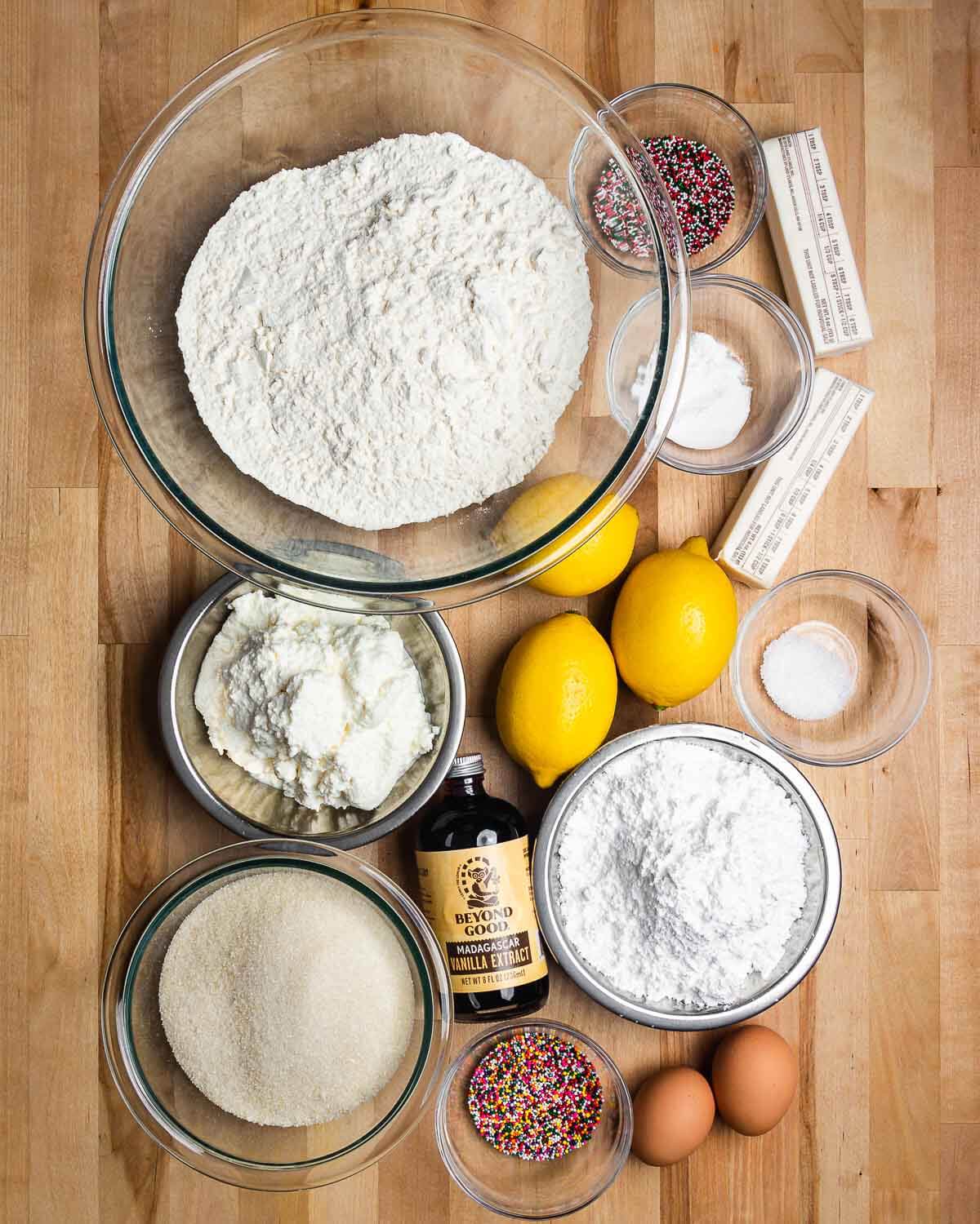 Ingredients shown: flour, sprinkles, butter, baking soda, baking powder, lemons, ricotta, vanilla extract, sugar, and eggs.